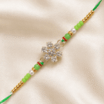 Detailed close-up of crystal snowflake Rakhi with green beads and pearl embellishments