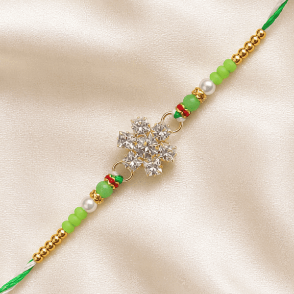 Detailed close-up of crystal snowflake Rakhi with green beads and pearl embellishments