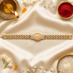 Festive flat lay of the Eshanarya Radhe Radhe Bracelet Rakhi with diya, kumkum, rice and white flowers for Raksha Bandhan.